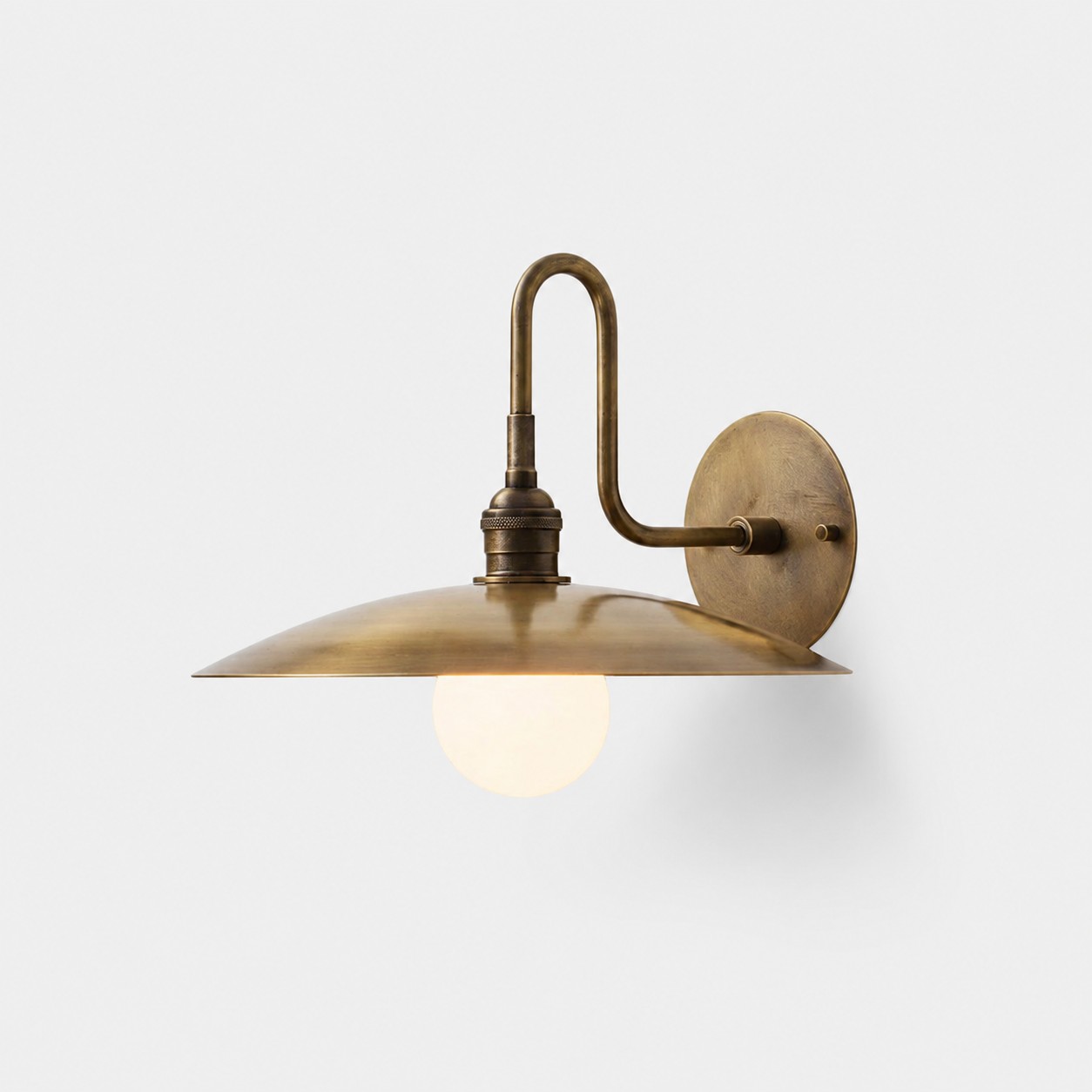Cantina antique brass wall lamp with curved arm and broad metal shade