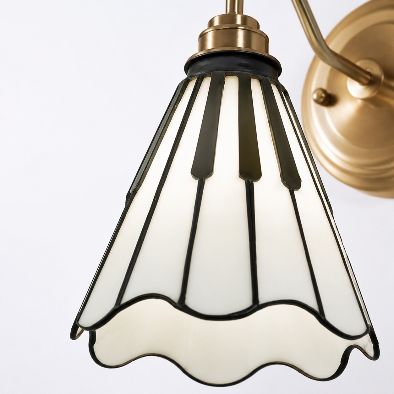 Pianoinspirerad glasskärm och mässingsfärgad vägglampa