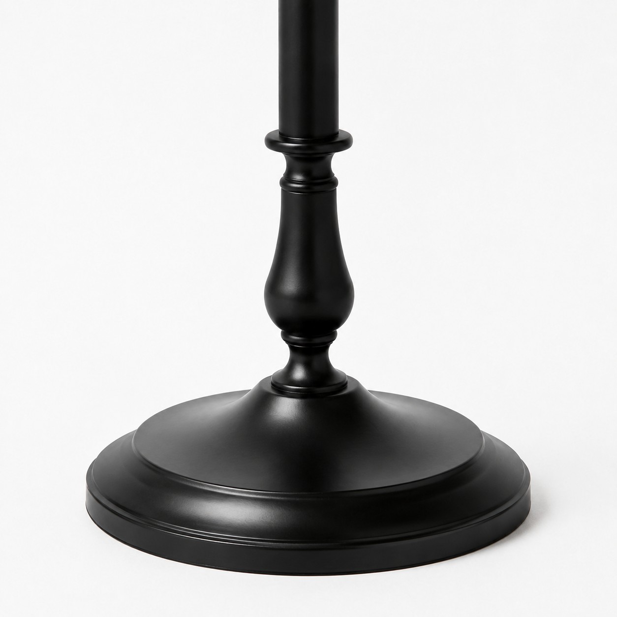 Gros plan sur le pied rond et stable en fer noir d'un lampadaire