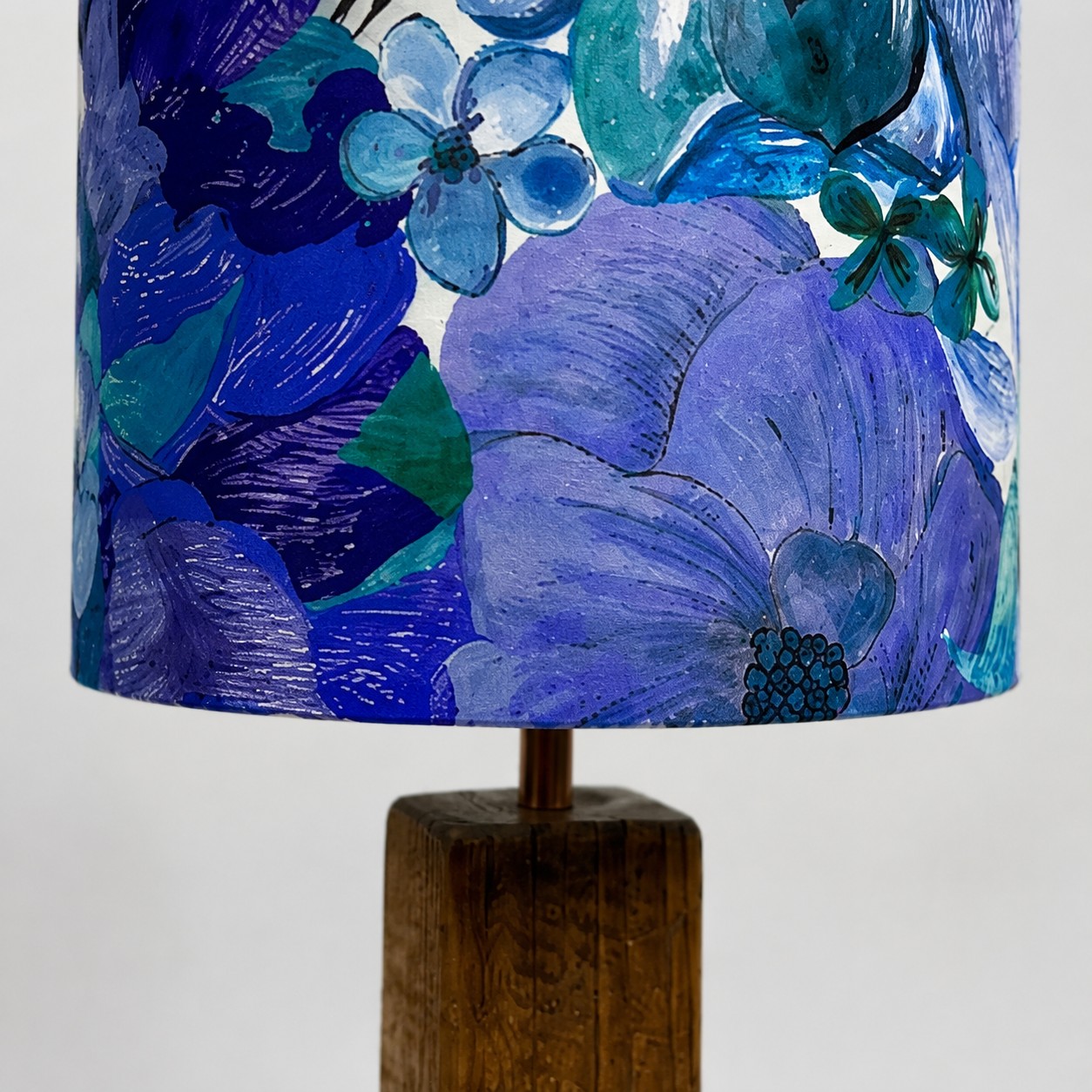 Close view of blue floral fabric lampshade and dark wood stem