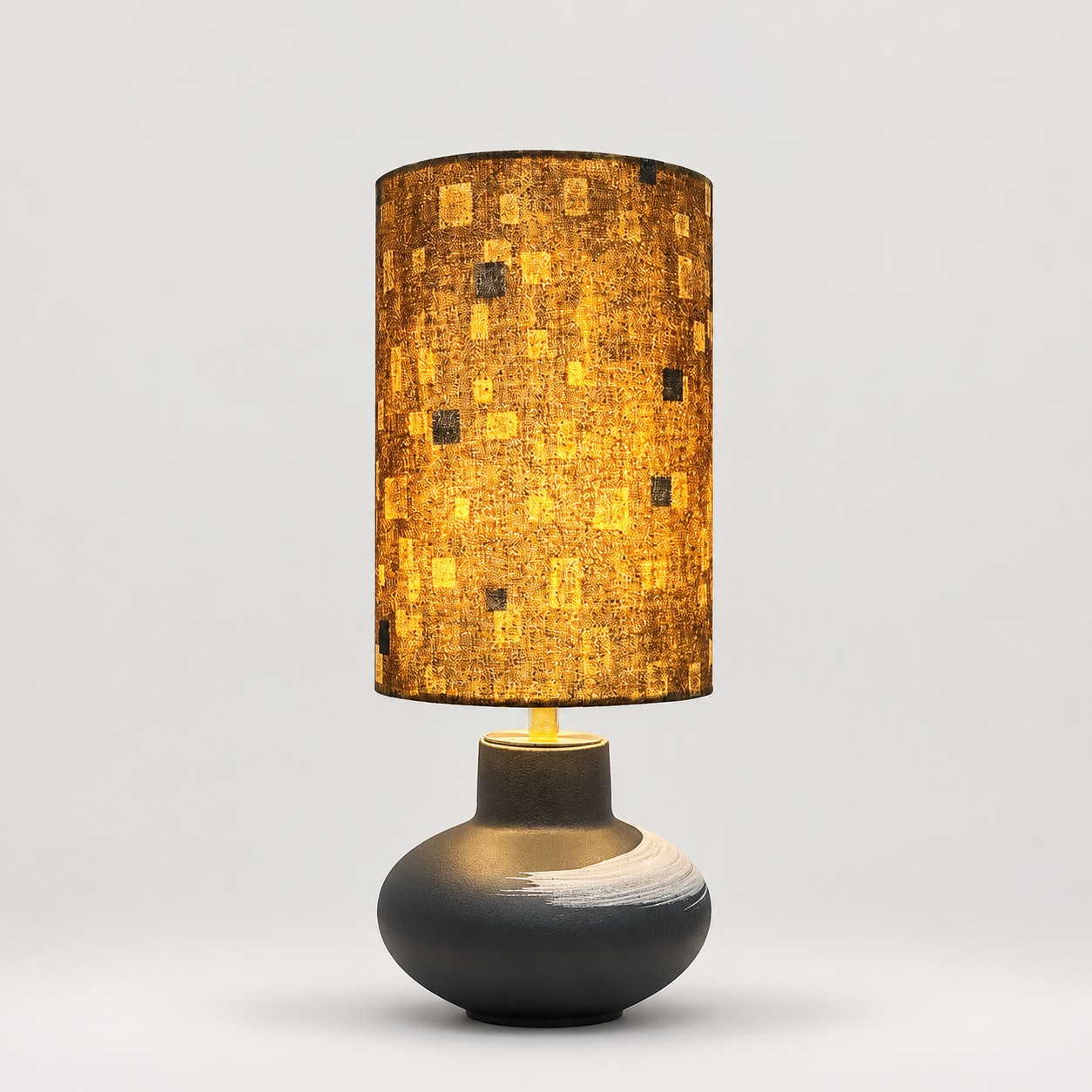 Lampe de table en céramique mouchetée dorée sur fond gris clair