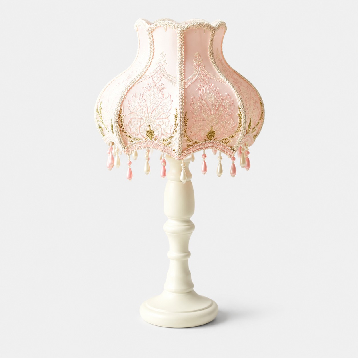 Pink beaded lace table lamp with fringe on a light background