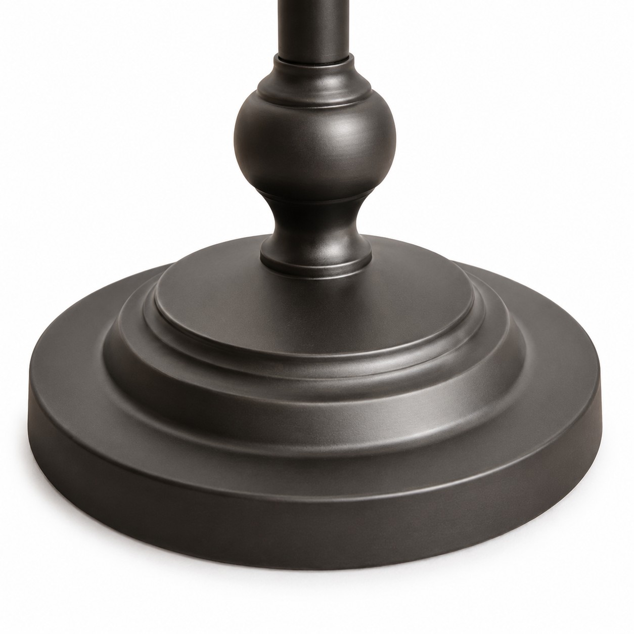 Gros plan sur le socle rond à plusieurs niveaux du lampadaire en métal noir