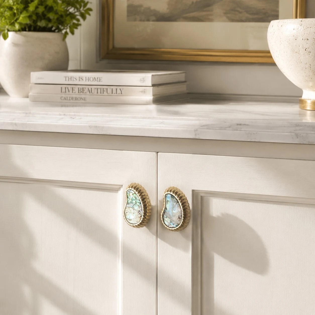 White shell brass knobs installed on light cabinetry