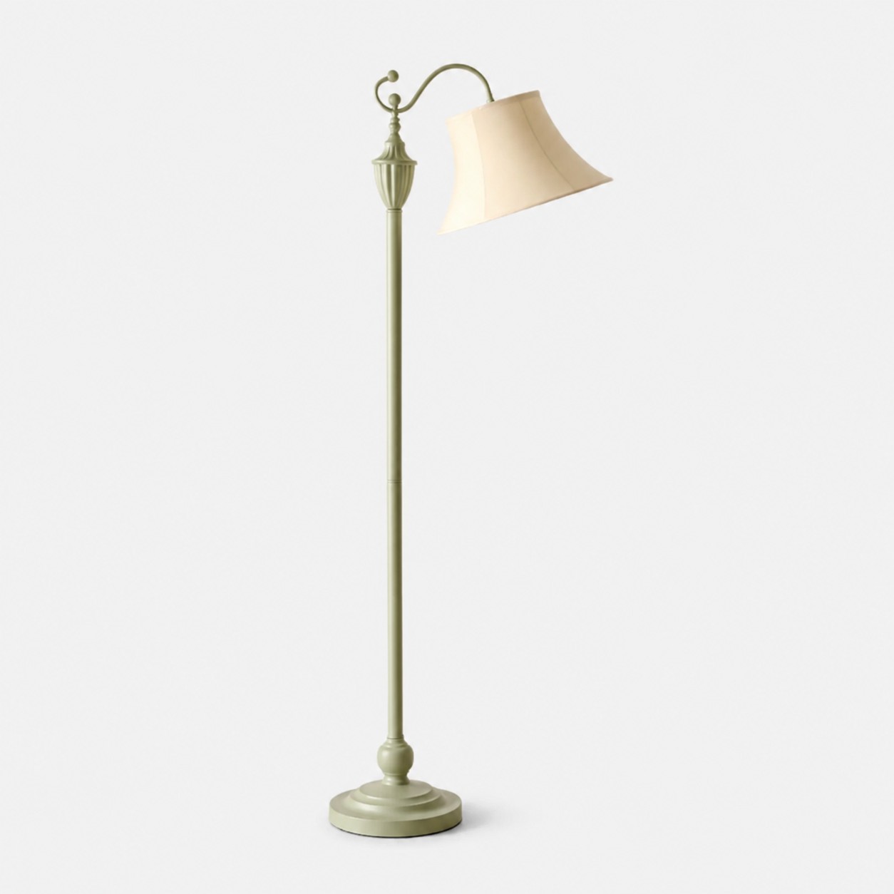Saliegroene staande lamp met gebogen armen en ivoorkleurige stoffen kap op een lichte achtergrond.