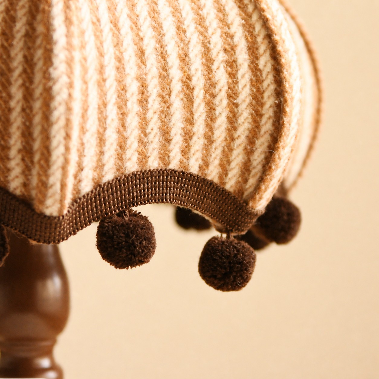 Close detail of the plush plaid fabric shade and pom pom fringe