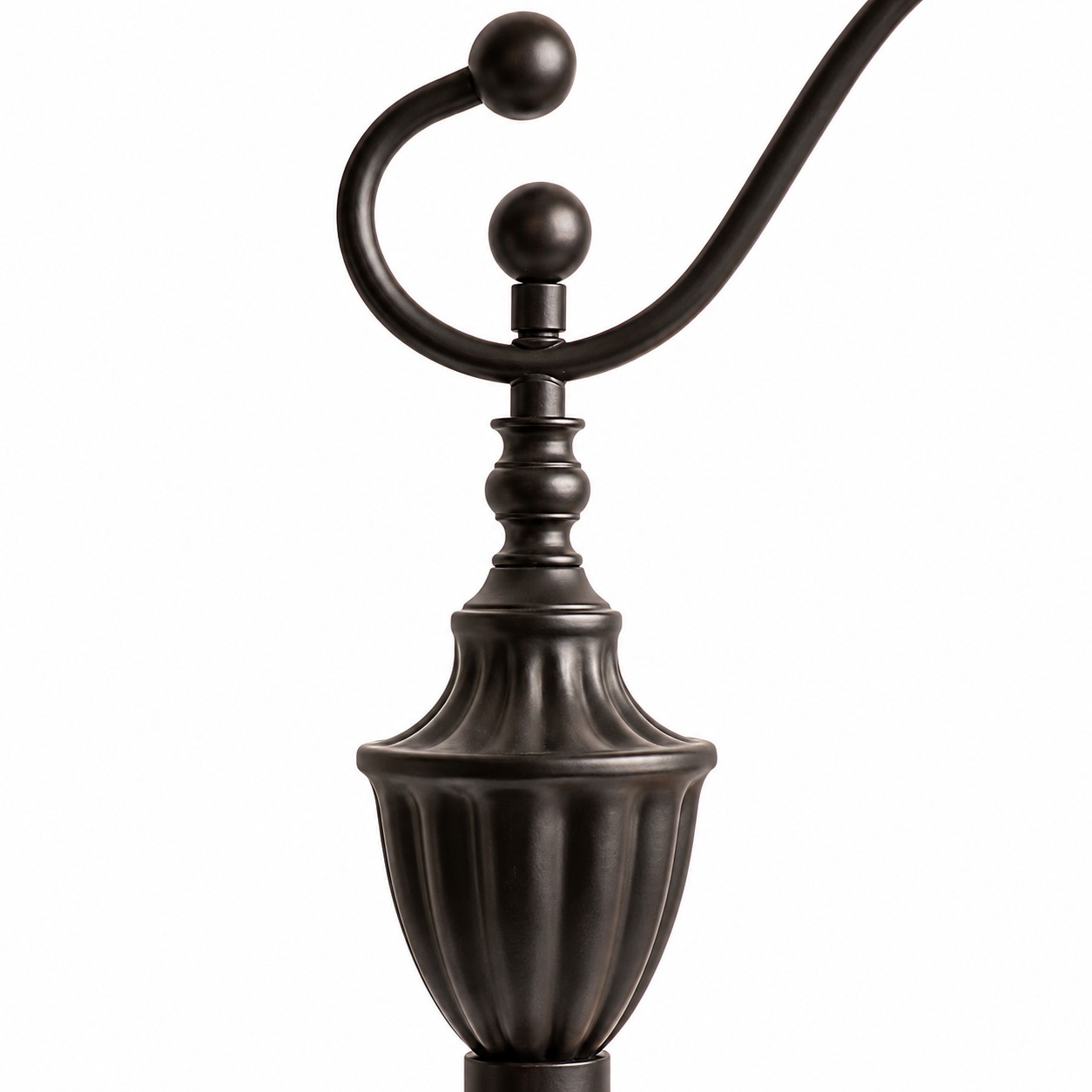 Gros plan sur le bras de lampe incurvé en métal noir et le poteau supérieur sculpté