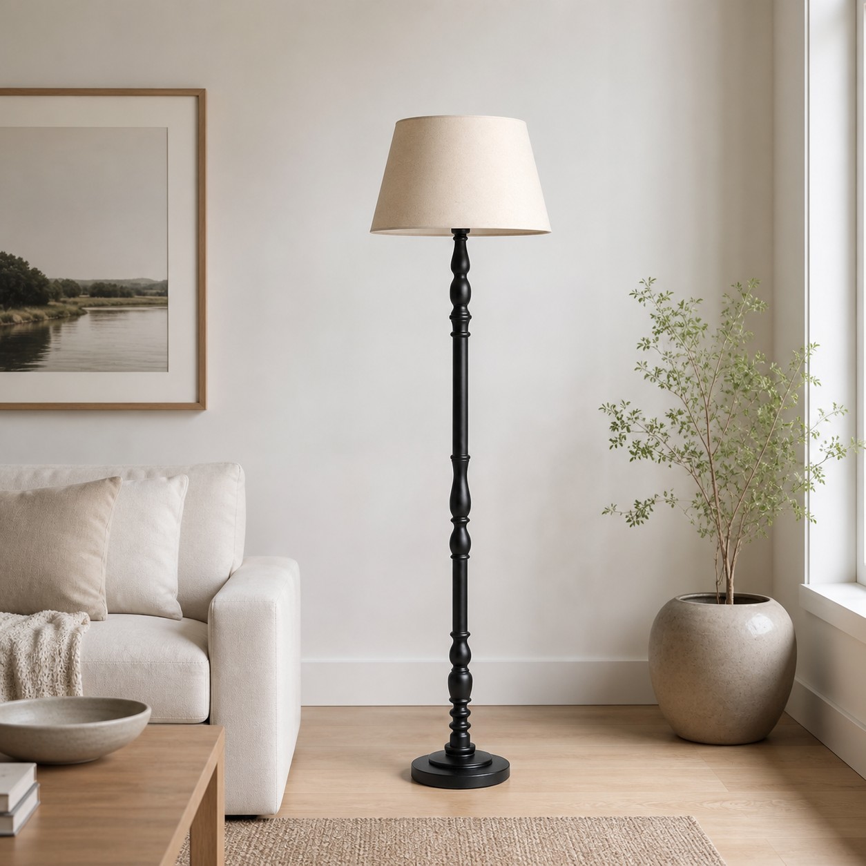 Zwarte staande lamp van gedraaid hout naast een lichte gestoffeerde fauteuil in een woonkamer.