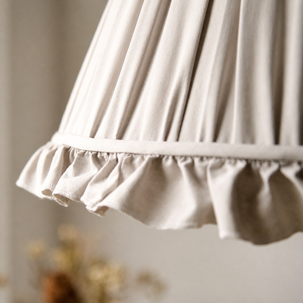 Close view of the pleated fabric shade and scalloped trim