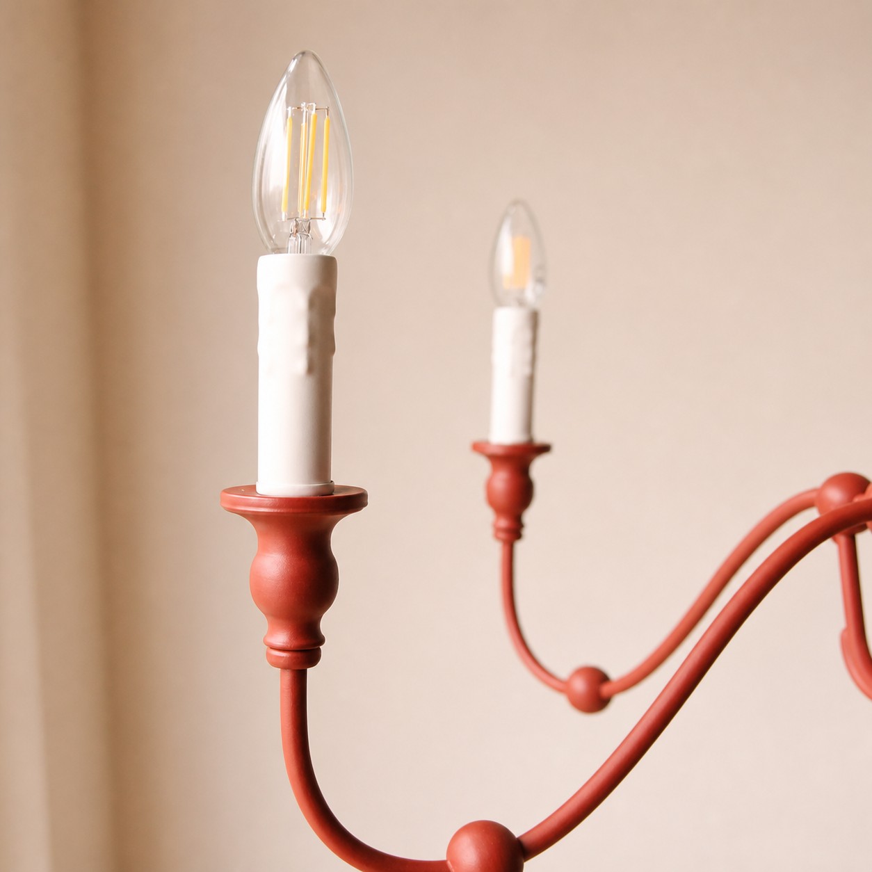 Vermilion red candle socket and curved iron arm detail