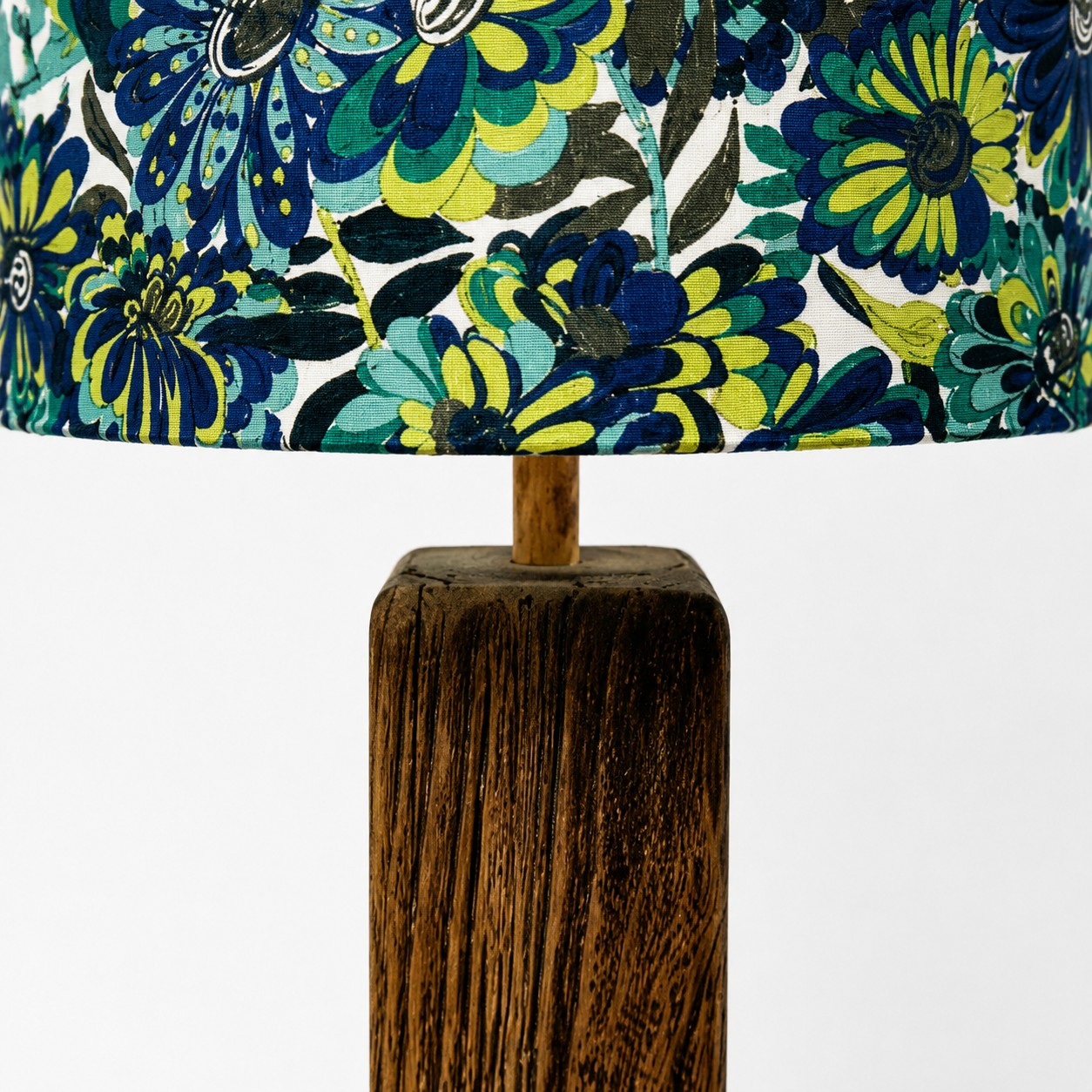 Close view of blue botanical textile shade and natural wood grain