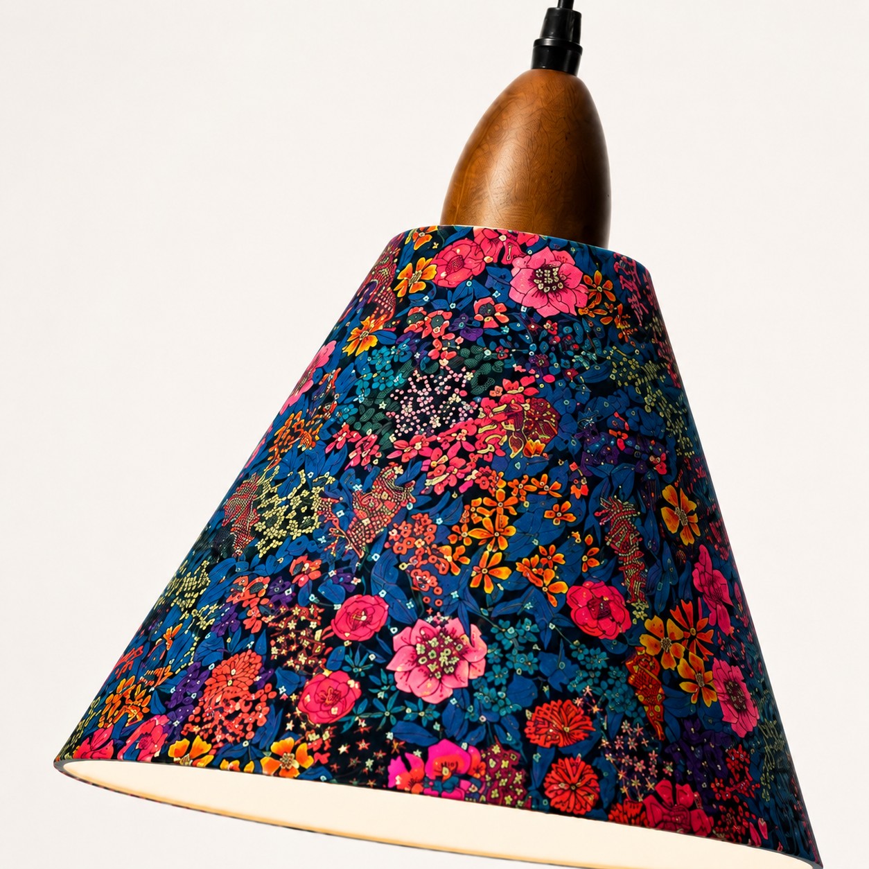 Angled view of dark botanical fabric shade and walnut-tone wood holder