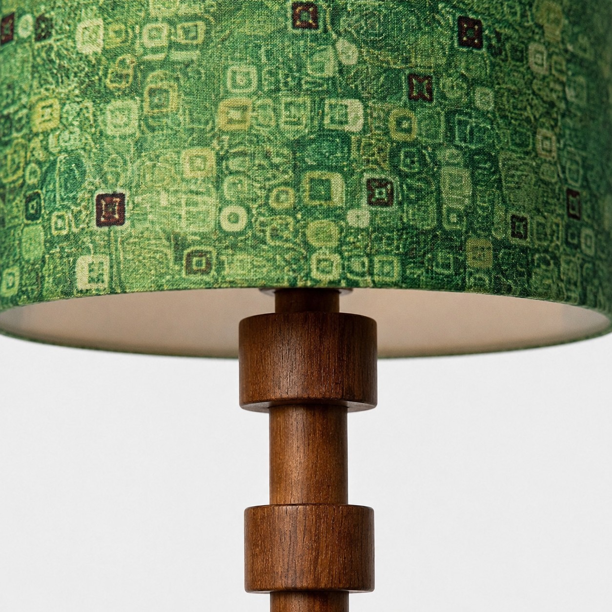 Patterned green fabric drum shade and turned wood column detail