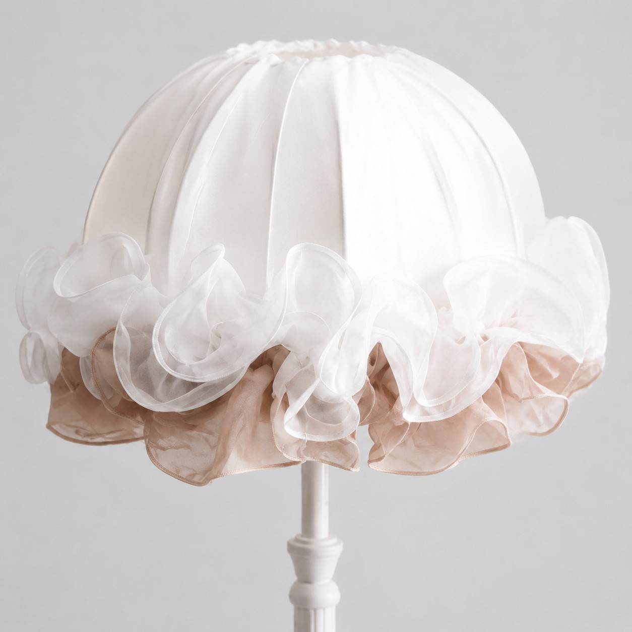 Close-up of layered white and blush ruffles on the gathered fabric lampshade