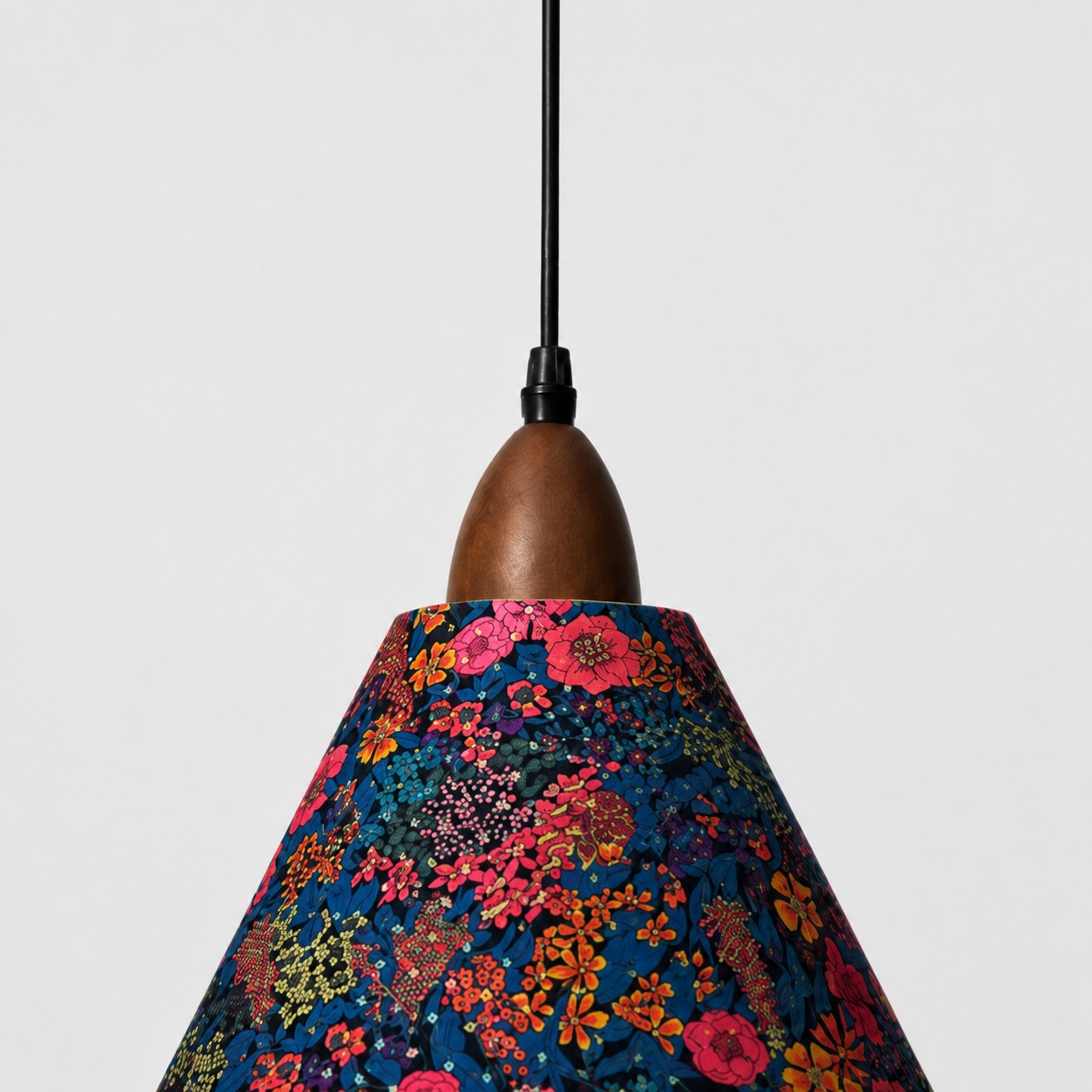 Close-up of walnut-tone wood lamp holder and dark botanical Liberty fabric