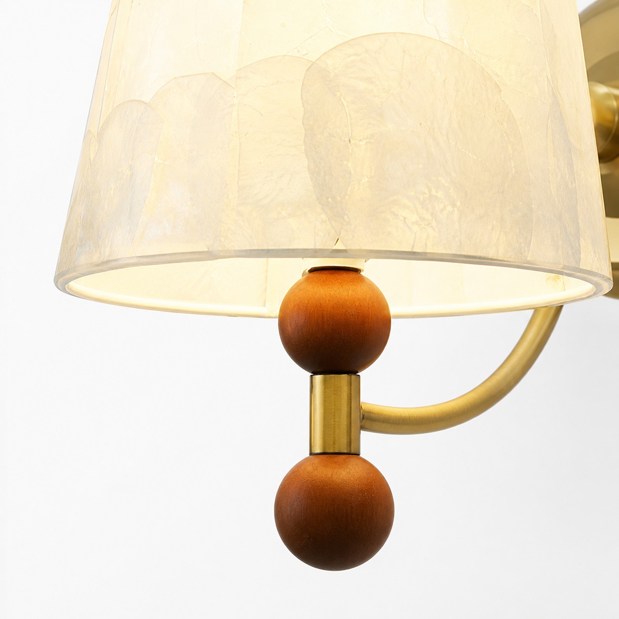 Close-up of warm wood sphere accents below the shell shade