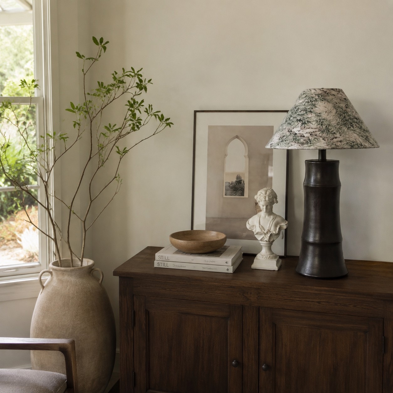 Lampe de table en céramique foncée posée sur une console en bois
