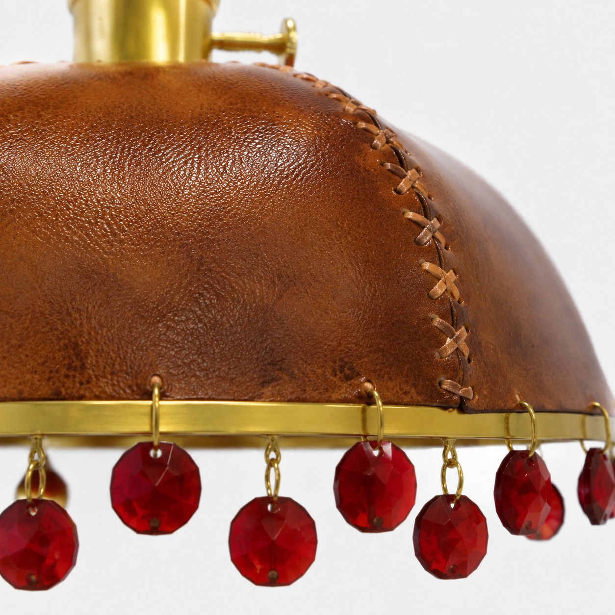 Leather, metal, and crystal details in a compact pendant silhouette