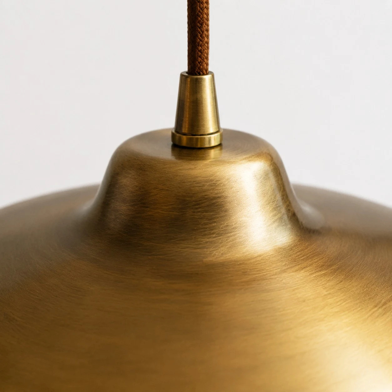 Close view of the brushed antique brass surface and cord connection