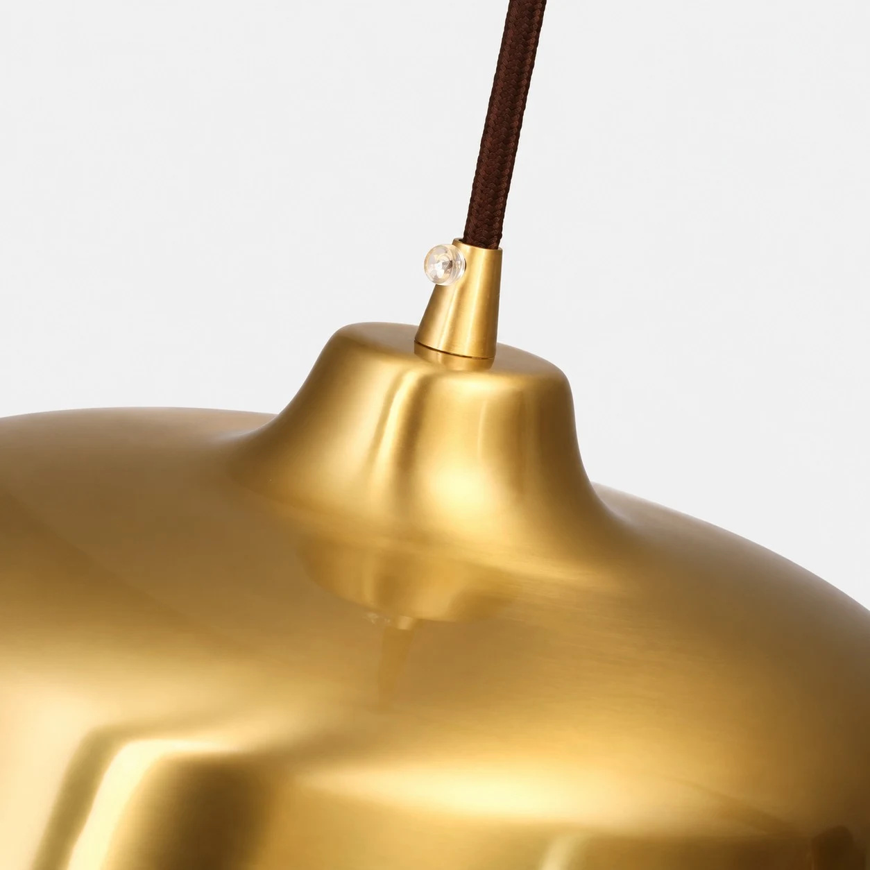 Close view of the smooth bright brass surface and cord connection