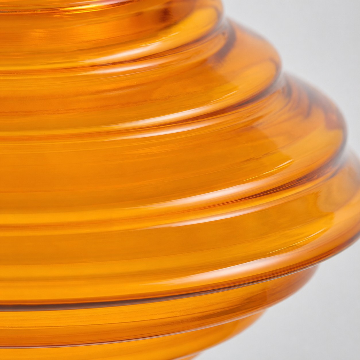 närbild av bärnstensfärgad ribbad glasskärm