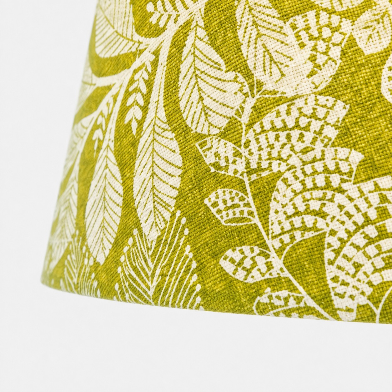Vue rapprochée de l’abat-jour en tissu tissé à motif botanique d’olivier