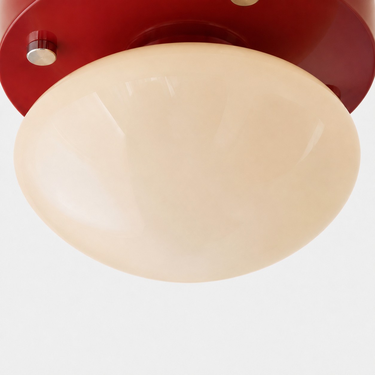 Närbild av krämfärgad glasdiffusor på röd LED-taklampa