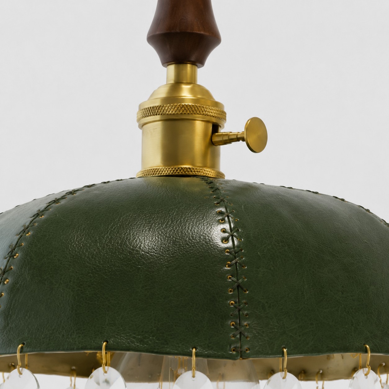 Leather, metal, and crystal details in a compact pendant silhouette