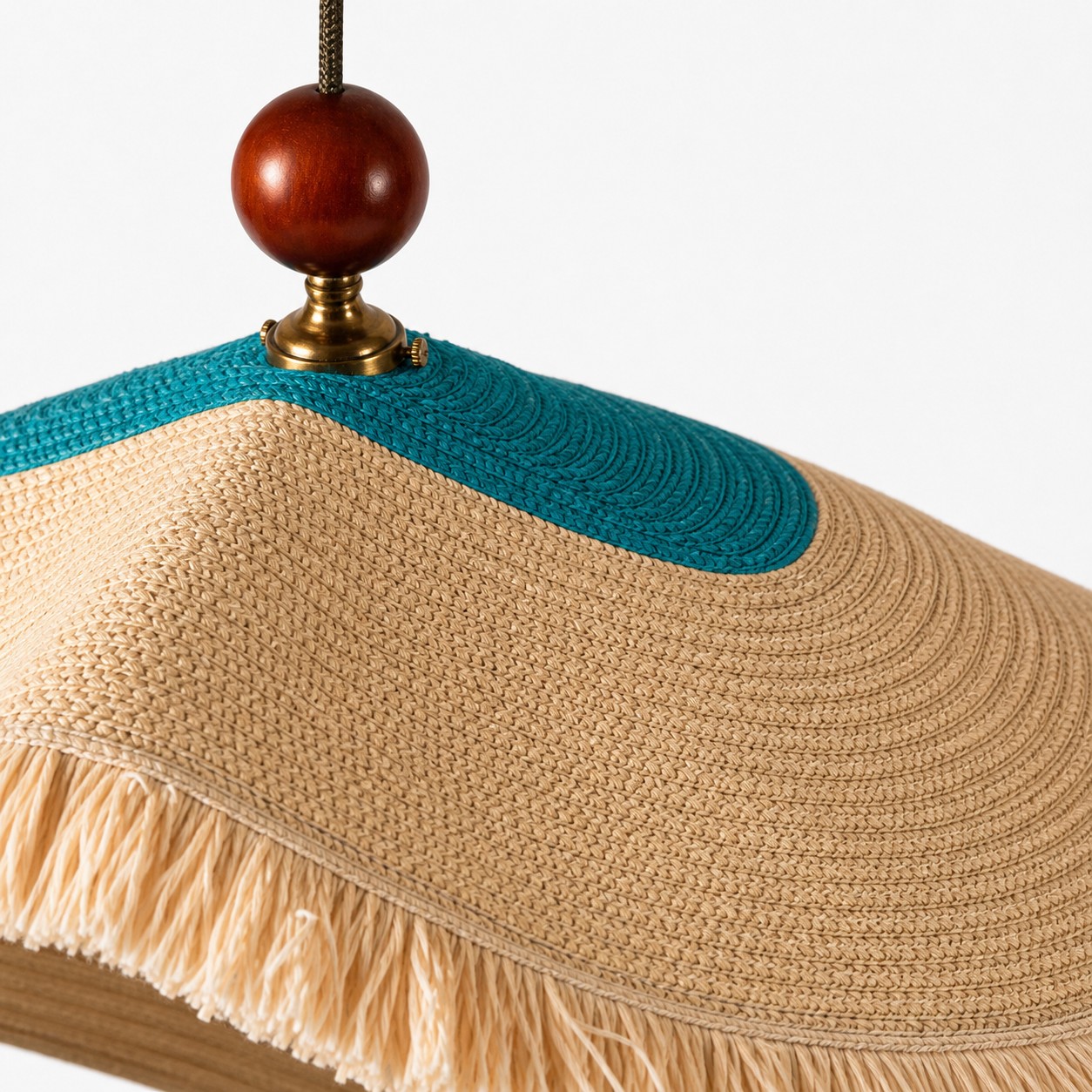 Detailweergave van de ivoorkleurige geweven lampenkap met franjes.