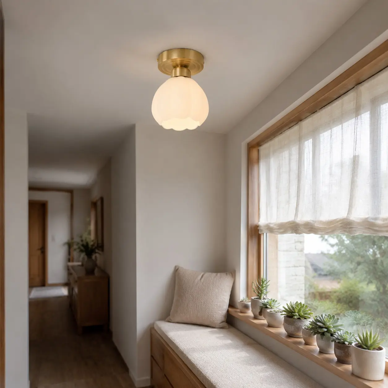 Plafonnier en verre opalin en forme de fleur au-dessus d'une banquette près de la fenêtre