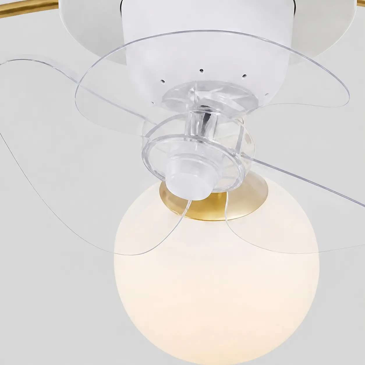 Primer plano de las aspas transparentes del ventilador y las esferas de cristal blanco.