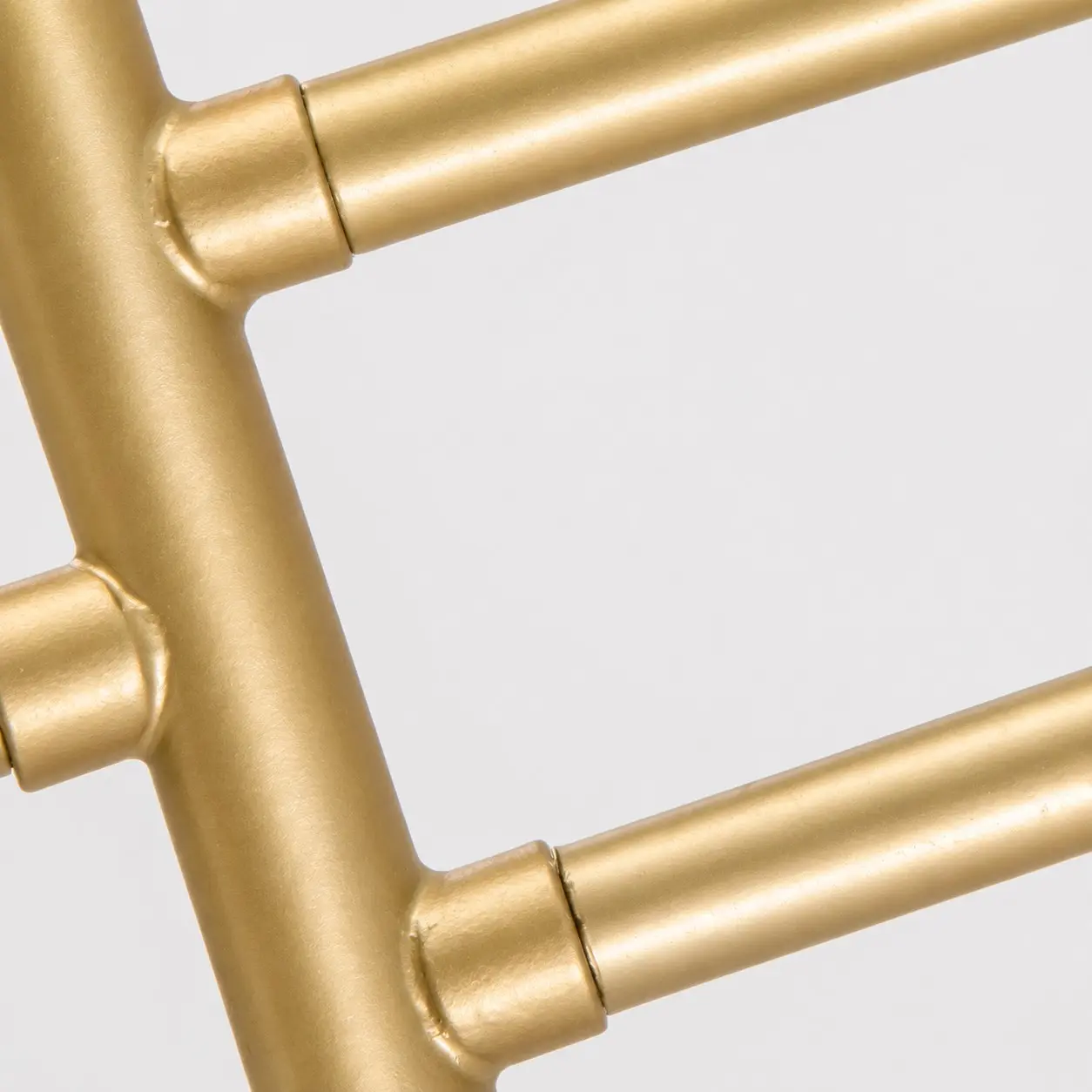 Nahaufnahme des gebogenen, goldfarbenen Metallrahmens