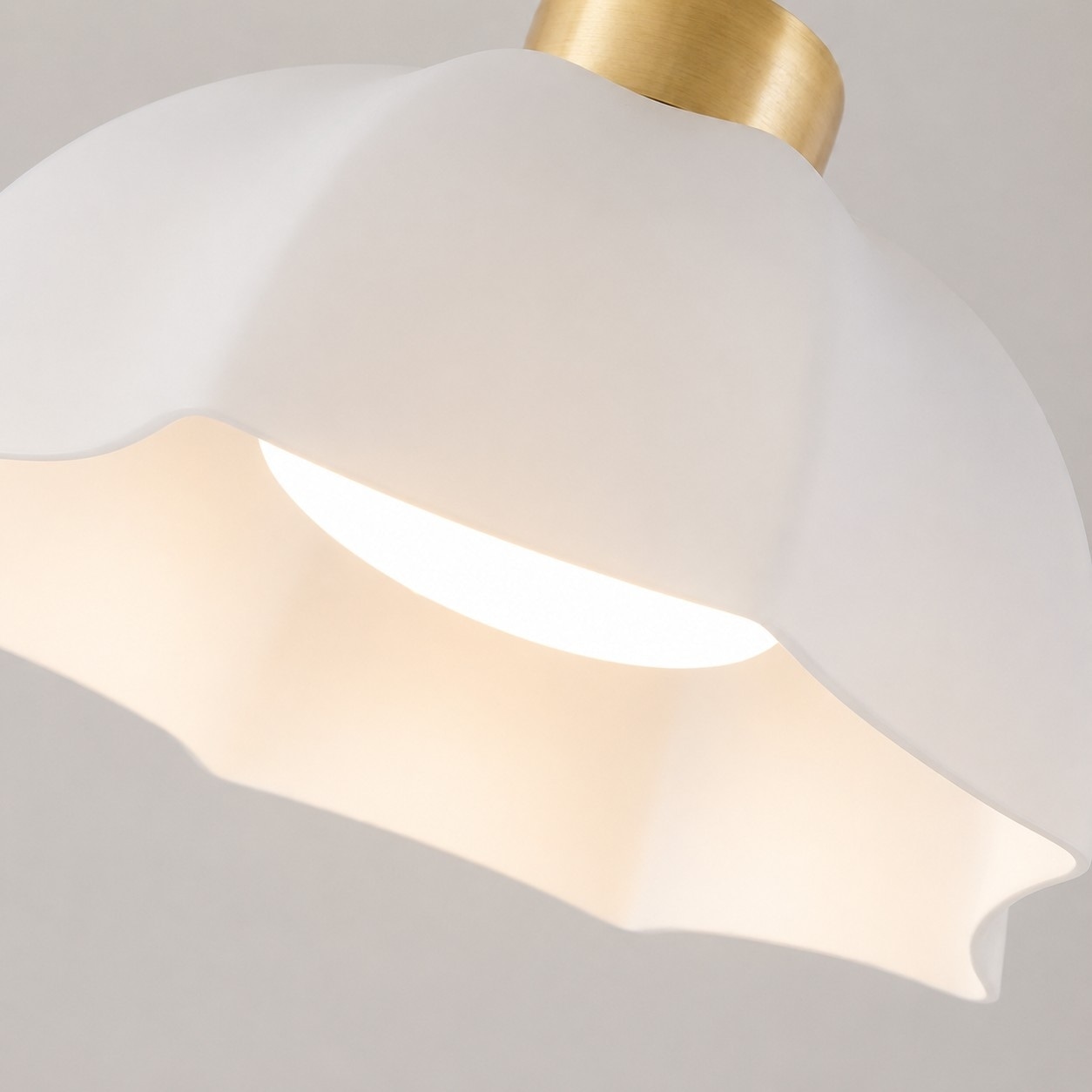 Gros plan sur un abat-jour en verre opalin blanc diffusant doucement la lumière
