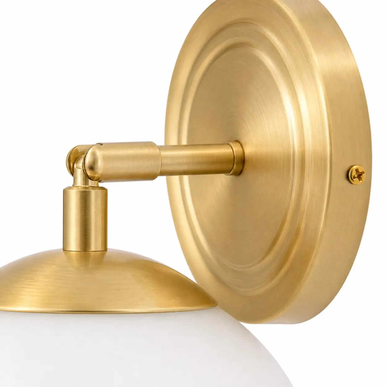 Placca a muro in oro spazzolato e dettaglio del braccio articolato della lampada.