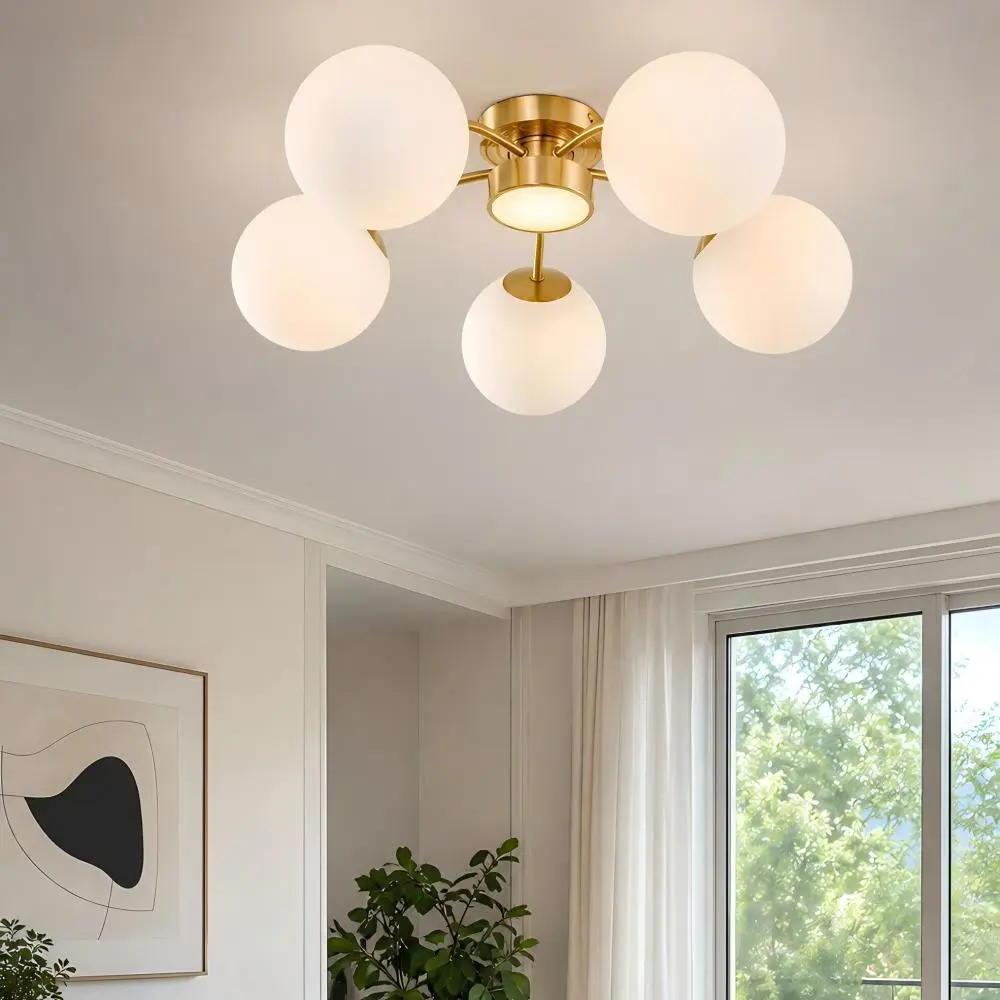 Lámpara de techo esférica de latón en un interior luminoso y contemporáneo.
