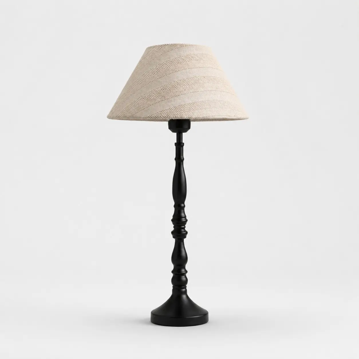 Beige tafellamp van rasterstof met zwarte ijzeren voet.