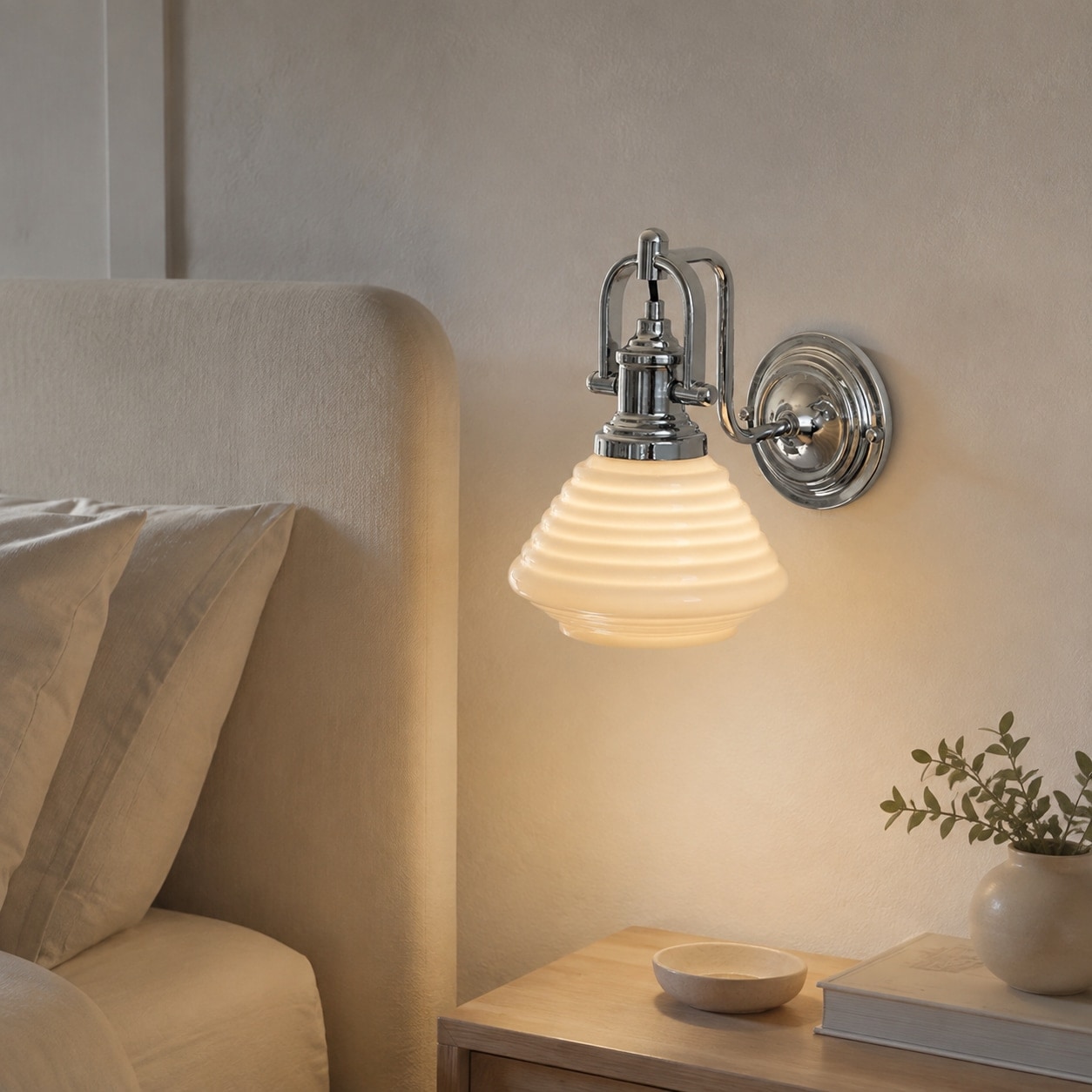 Creamy yellow glass wall sconce beside a bed