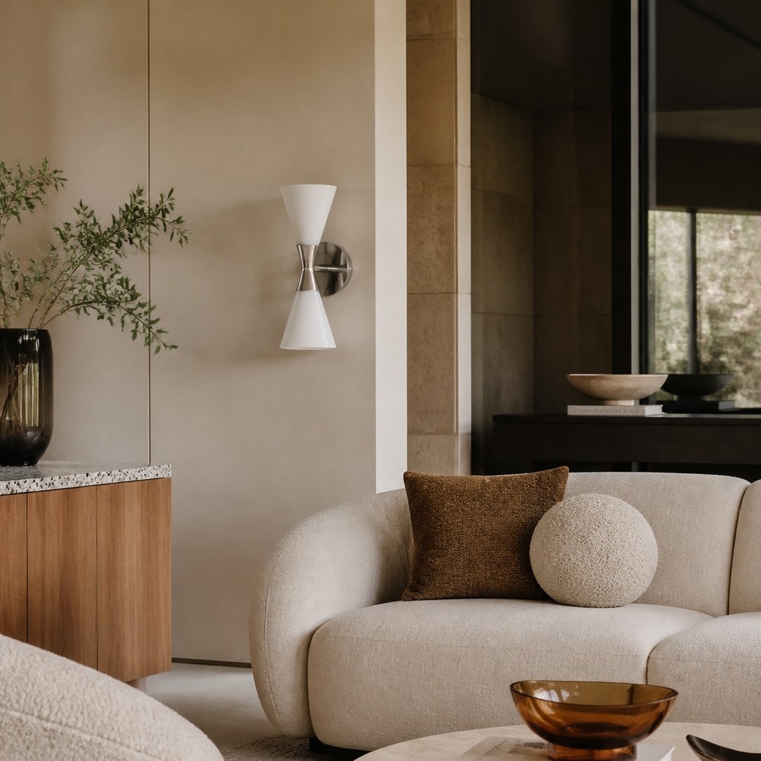 White glass wall sconce above a console table in a warm modern room