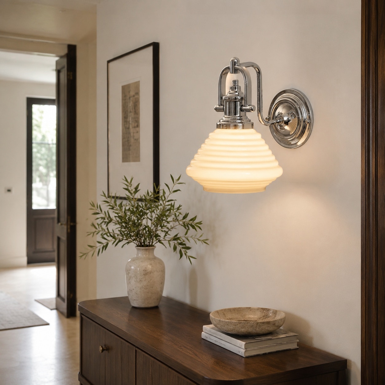 Creamy yellow glass wall sconce in an entry console setting