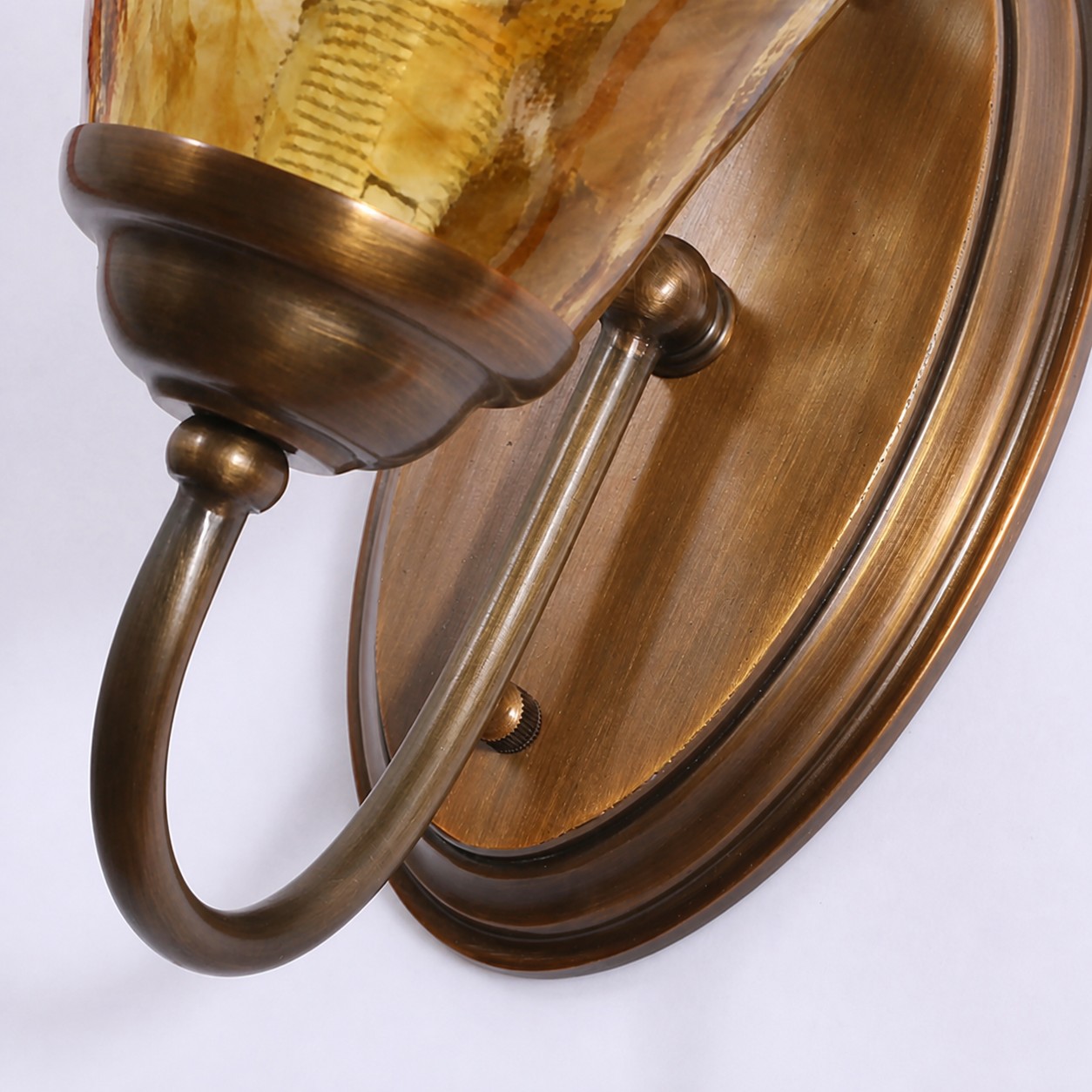 Curved brass arm and oval wall plate