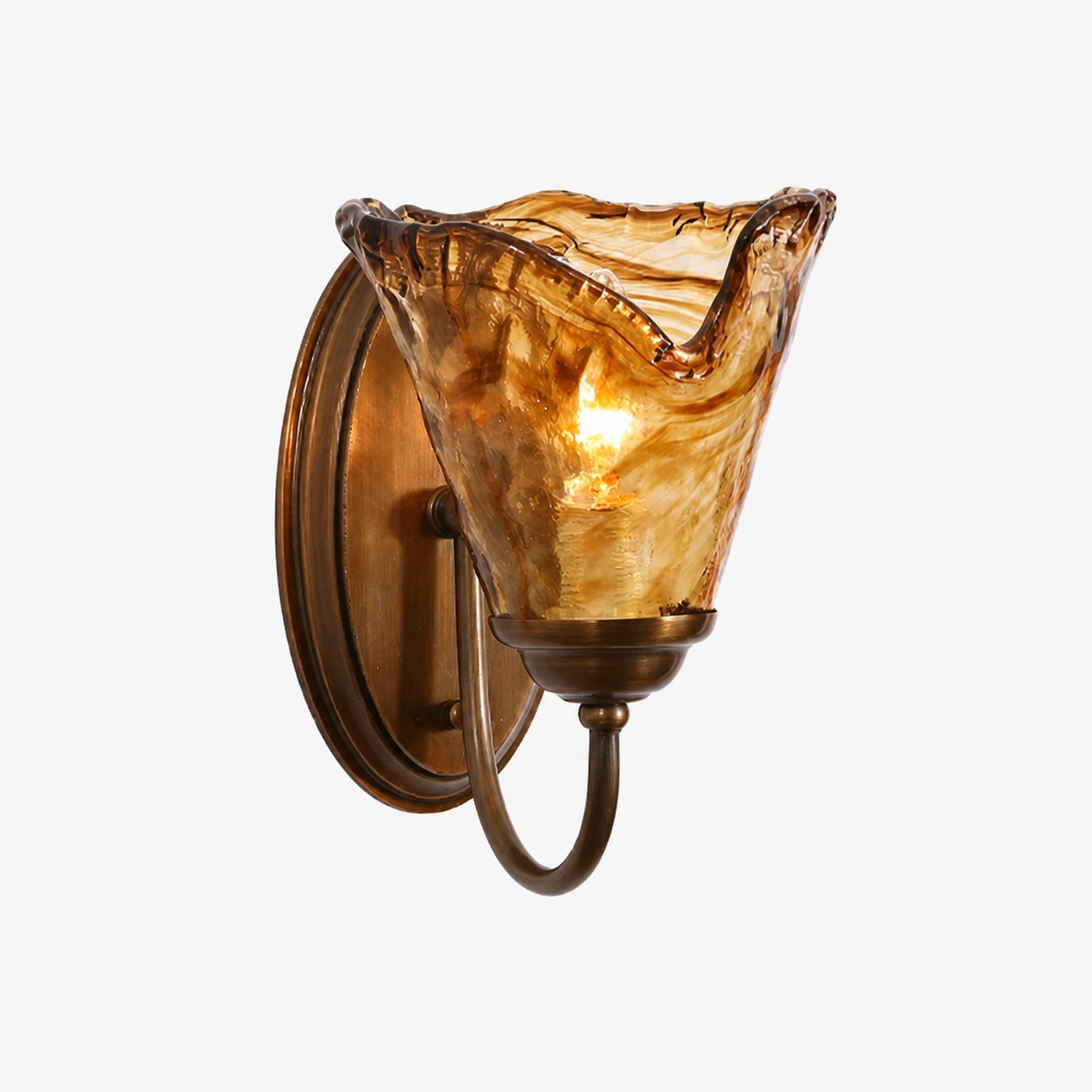 Sculpted amber glass and brass wall sconce
