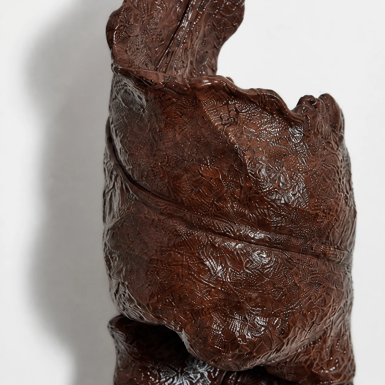 Close-up of dark brown resin finish and sculptural surface texture
