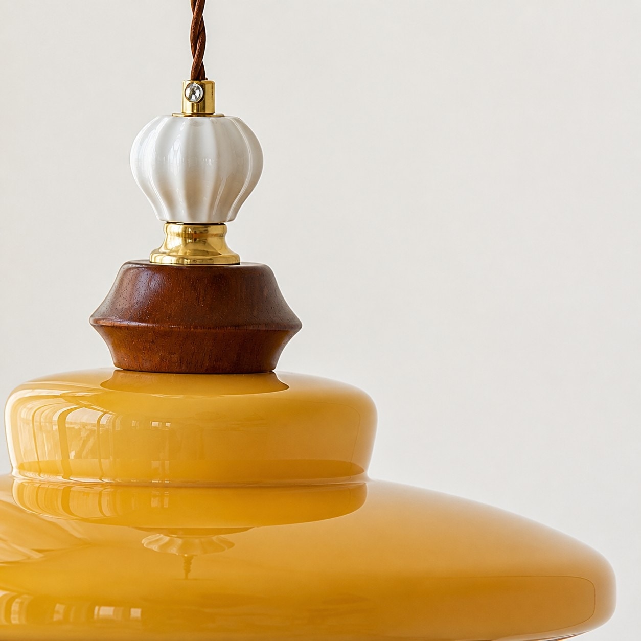 Pendant cord, wood accent, and caramel glass shade detail