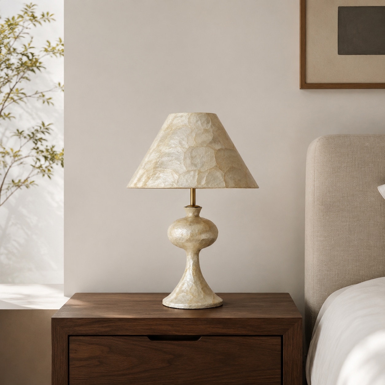 Eine Tischlampe aus Capiz-Muscheln auf einem hölzernen Nachttisch in einem warmen Schlafzimmer