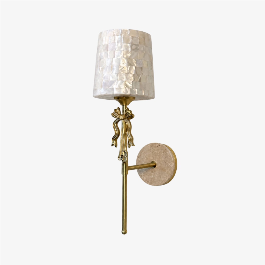 Aplique de pared con lazo de concha de capiz beige sobre un fondo limpio.