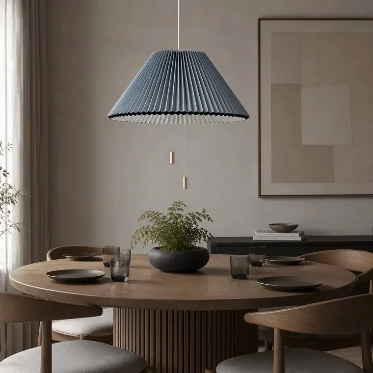 Adjustable pleated pendant light above a dining table with on and off lighting effect