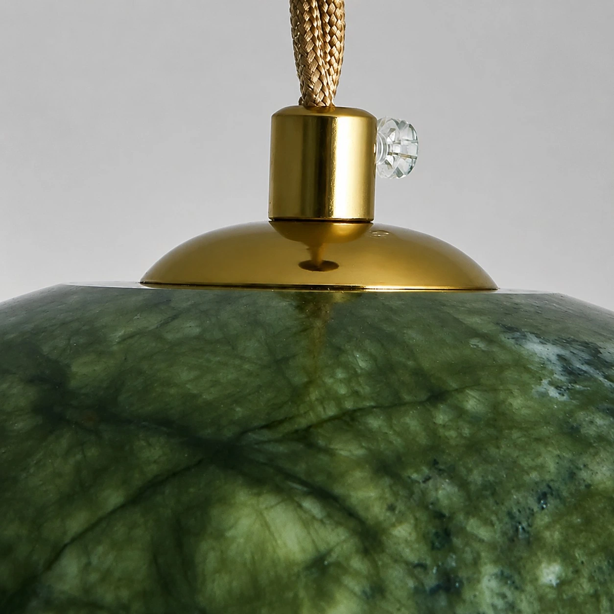 Close view of the brass-tone shade fitting and braided cord