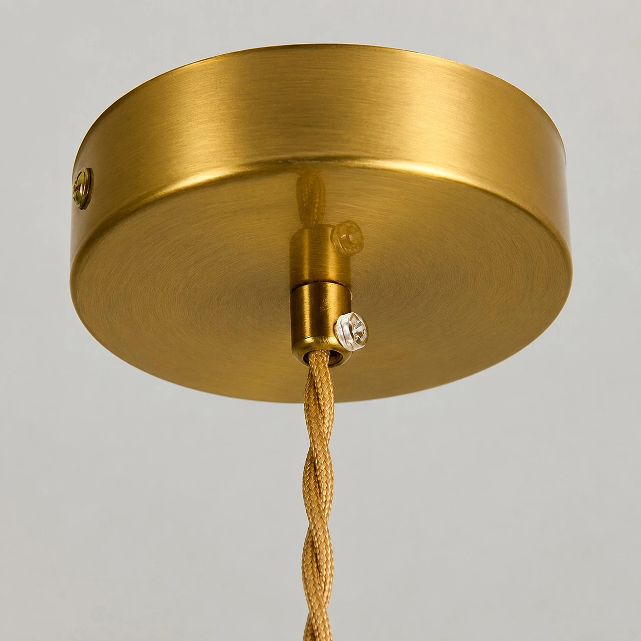 Close view of the brass-tone ceiling canopy and cord