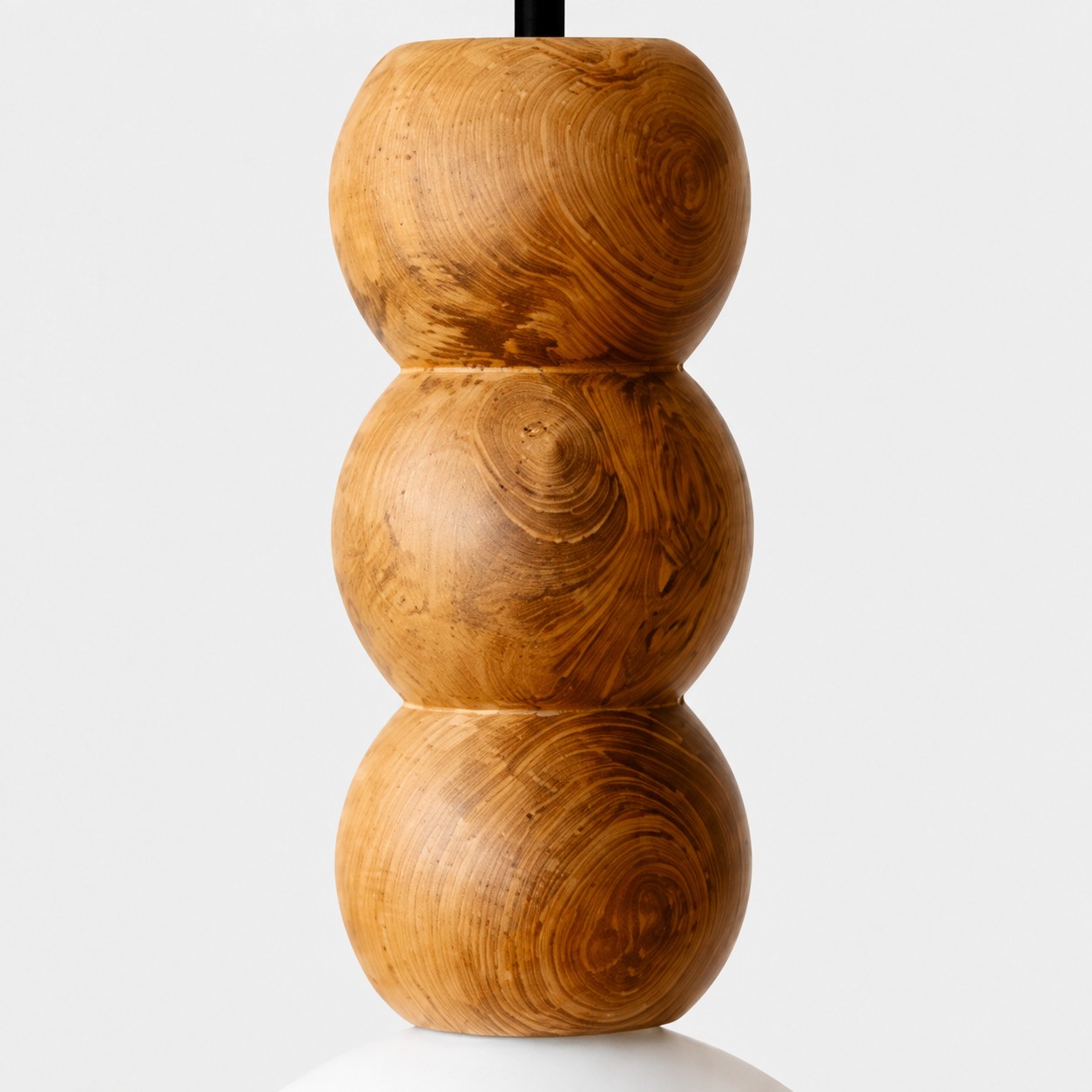 Close view of three sculpted wood beads with distinctive grain patterns