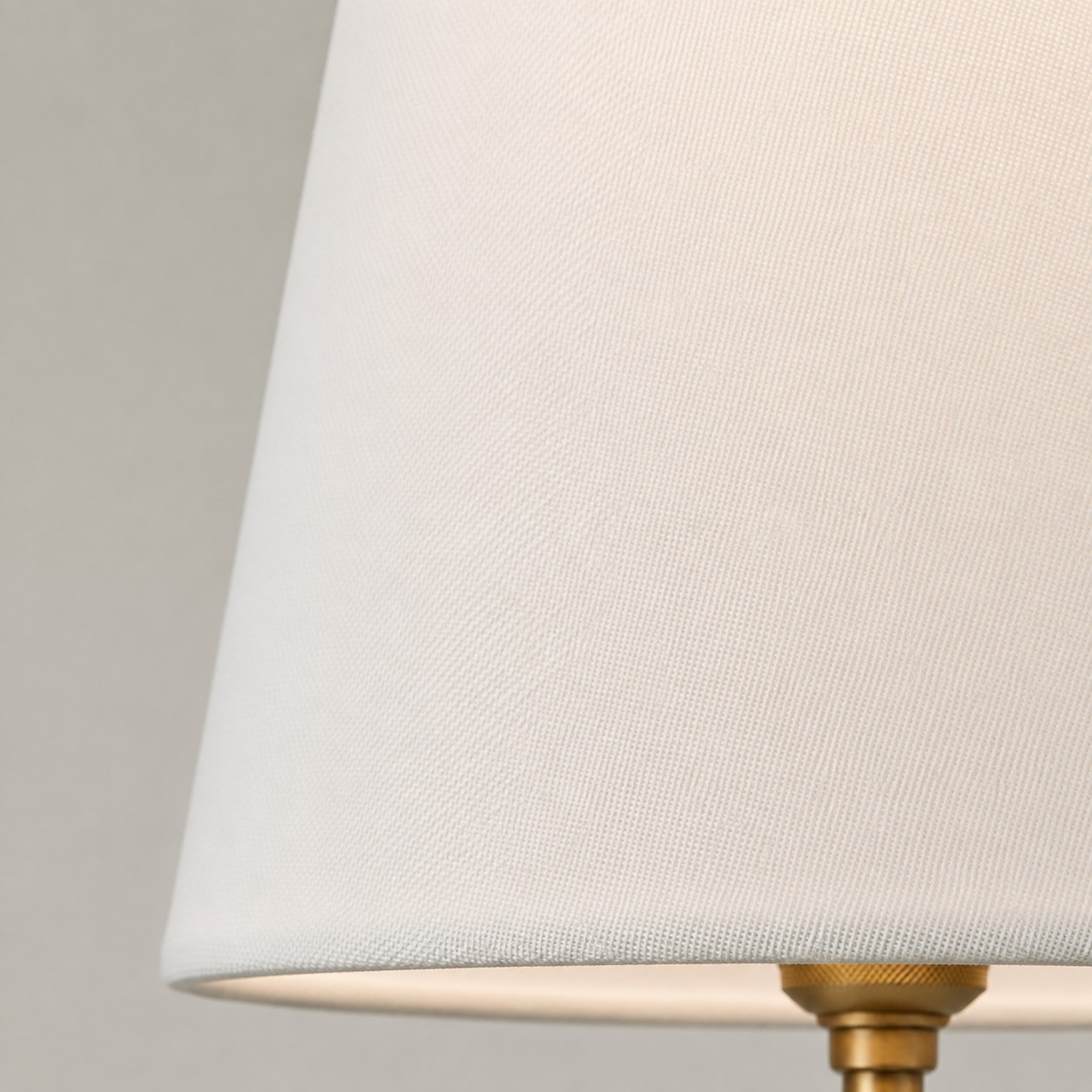 Detailweergave van een geweven witte stoffen lampenkap.